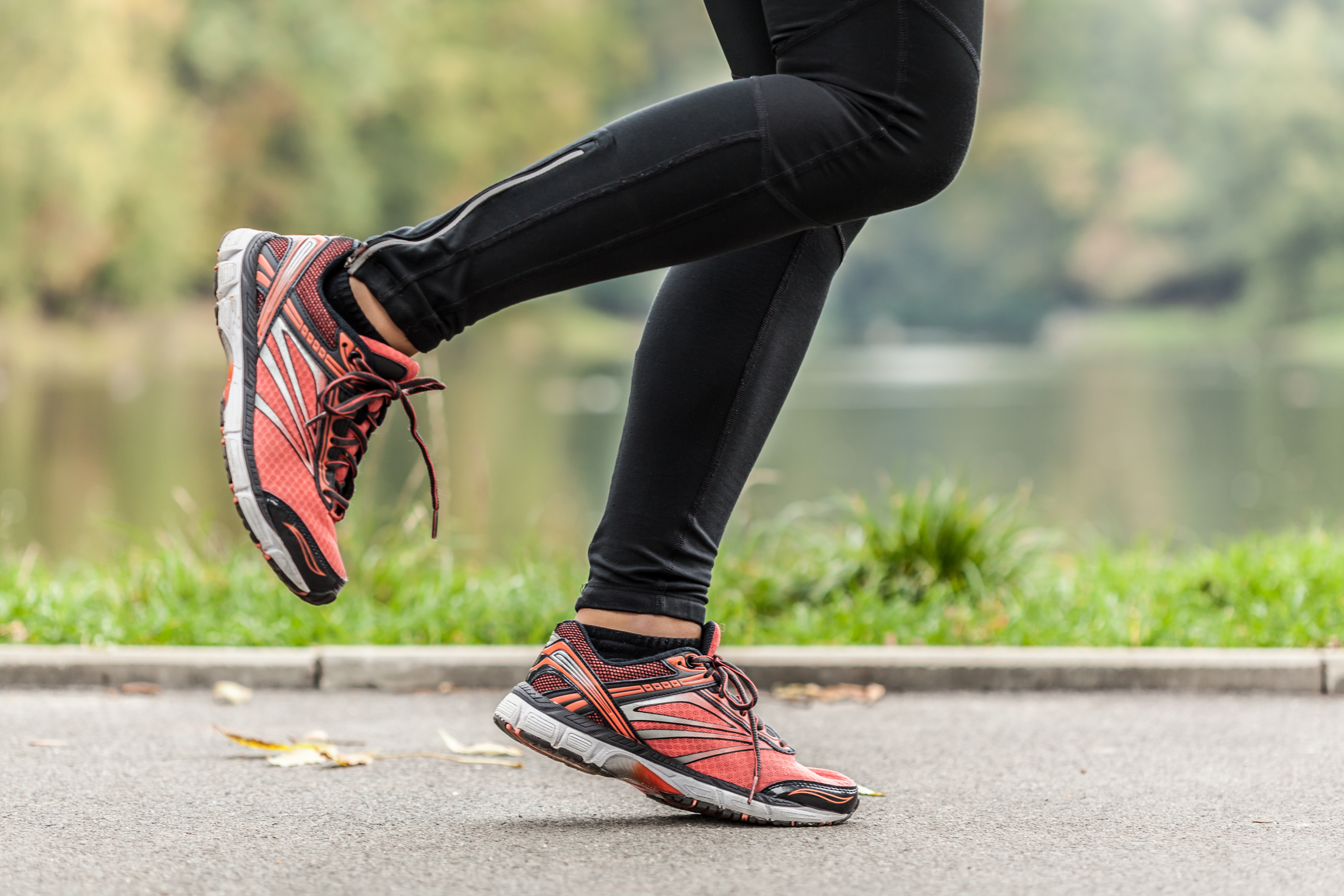 Close-up of young running in park woman's feet